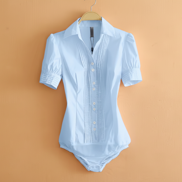 A light blue short-sleeve button-front bodysuit or romper with a pointed collar and vertical pleat detailing on the chest, hanging on a wooden hanger against a peach-colored wall. The text 'Fourthshop women outfits' is visible in the top-left corner.