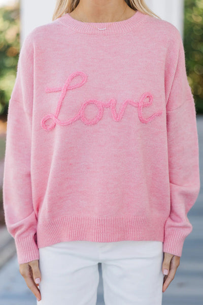 Cozy Women's Pink Baggy Graphic Sweater with Love Script - Effortless Casual Chic for Everyday Style made for easy styling and wardrobe coordination,